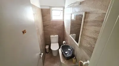 a small bathroom with a toilet and a mirror at Warm Design 3BR, Beach 7-min walk, Peaceful in Larnaka