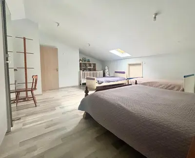 a large bedroom with a bed and a chair at Spacious 1 bedroom apartment with an attic bedroom in Strovolos