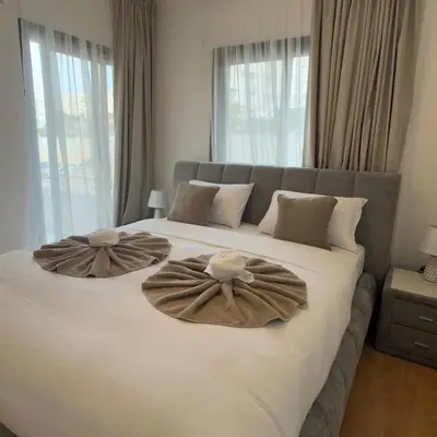 a bedroom with a large bed with two pillows on it at Aphrodite Limassol Apartment in Limassol