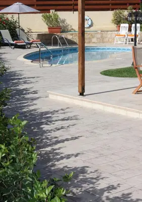 a patio with a swimming pool with a table and chairs at Luxury Villa Rental, Two Bedroom Villa with private pool and garden, in Pissouri