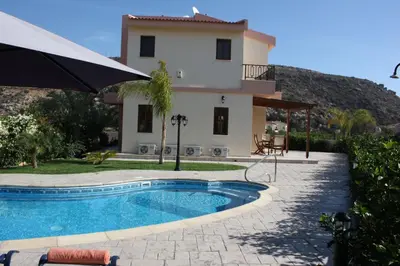 a villa with a swimming pool in front of a house at Luxury Villa Rental, Two Bedroom Villa with private pool and garden, in Pissouri