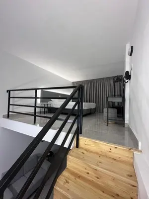 a staircase leading up to a room with two beds at SeaCity Stays in Larnaka