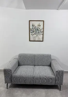 a gray couch in a room with a picture on a wall at SeaCity Stays in Larnaka