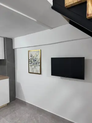 a living room with a tv on a white wall at SeaCity Stays in Larnaka