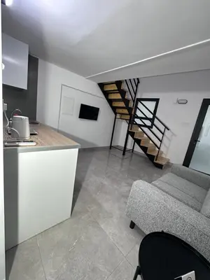 a kitchen and a living room with a spiral staircase at SeaCity Stays in Larnaka