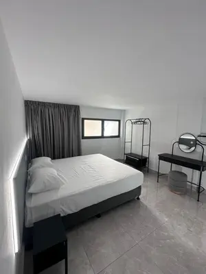 a bedroom with a white bed and a window at SeaCity Stays in Larnaka