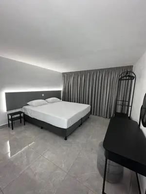 a bedroom with a bed and a desk in it at SeaCity Stays in Larnaka