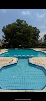 a large swimming pool with blue tiles on the ground at 3 bedroom Villa in Kyrenia, 2 minutes away from the beach! in Strovolos