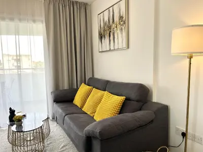 a living room with a gray couch and yellow pillows at STAY Sun Line Apartment in Nicosia