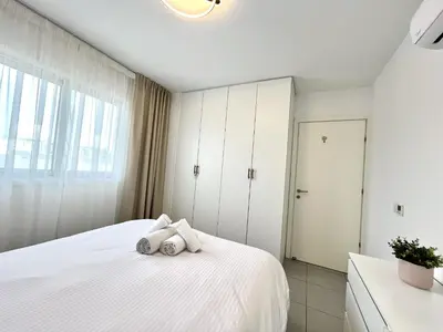 a bedroom with a white bed with towels on it at STAY Sun Line Apartment in Nicosia