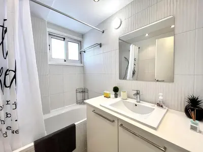 a bathroom with a sink and a tub and a mirror at STAY Sun Line Apartment in Nicosia