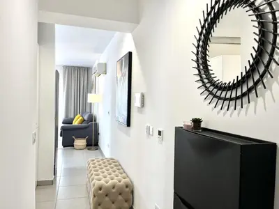 a living room with a chair and a mirror at STAY Sun Line Apartment in Nicosia