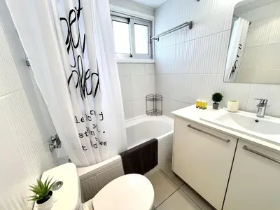 a white bathroom with a toilet and a sink at STAY Sun Line Apartment in Nicosia