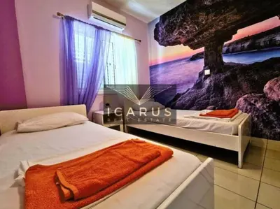 a bedroom with two beds and a painting on the wall at Seana Kapparis Apartment with Private Pool in Aglantzia