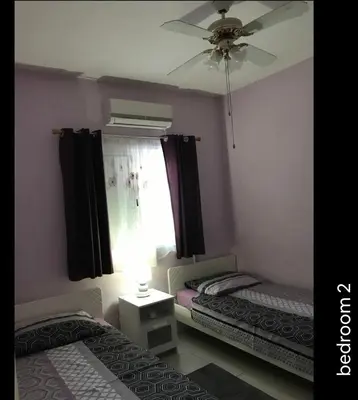 two beds in a room with a ceiling fan and a window at Seana Kapparis Apartment with Private Pool in Aglantzia