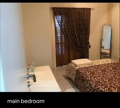 a bedroom with a bed and a mirror and a window at Seana Kapparis Apartment with Private Pool in Aglantzia
