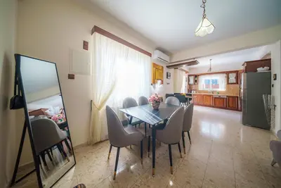 a dining room with a table and chairs and a kitchen at The Nissi Duo Collection in Ayia Napa