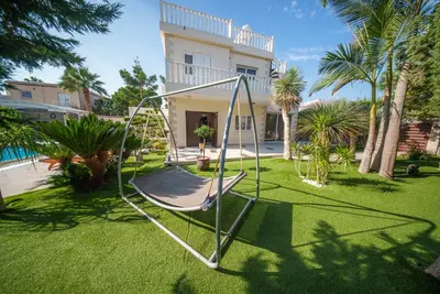 a swing in a yard in front of a house at The Nissi Duo Collection in Ayia Napa