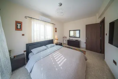 a bedroom with a large bed and a television at The Nissi Duo Collection in Ayia Napa