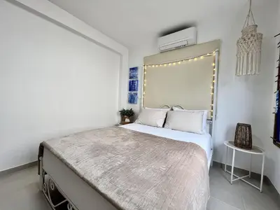 a bedroom with a large bed in a white room at STAY Blue House in Larnaka