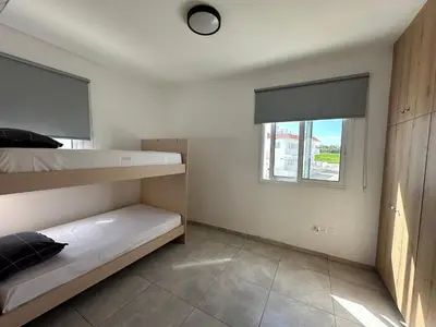 a bedroom with two bunk beds and a window at Ocean Breeze 2BR House in Paralimni