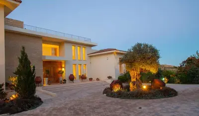 a house with a tree in front of it at Epavli Papadopoulou - Luxury Villa - Pool & Garden in Kornos