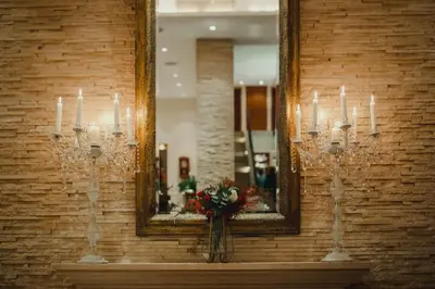 a mirror on a wall with candles and a vase with flowers at Epavli Papadopoulou - Luxury Villa - Pool & Garden in Kornos