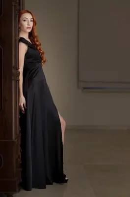a woman in a black dress leaning against a wall at Epavli Papadopoulou - Luxury Villa - Pool & Garden in Kornos
