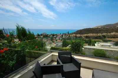 a balcony with two chairs and a view of the ocean at Villa Acanthus in Pissouri