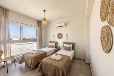 two beds in a room with a window at Protaras Hestia Seaside Villa A6 in Protaras