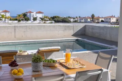 a table with fruit and juice on top of a balcony at Protaras Hestia Seaside Villa A6 in Protaras
