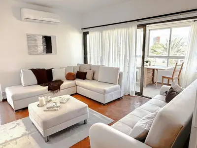 a living room with a white couch and a table at The Perfect Lefkosa Stay - Zahra & Dereboyu & Ledra in Nicosia