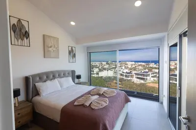 a bedroom with a bed and a large window at Living the View in Protaras