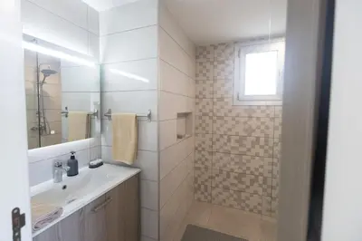 a white bathroom with a sink and a mirror at Living the View in Protaras