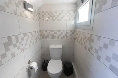a bathroom with a toilet and a window at Living the View in Protaras