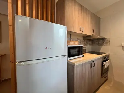 a white refrigerator in a kitchen with wooden cabinets at Monte Napa Moments in Ayia Napa