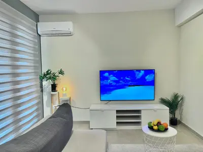 a living room with a couch and a flat screen tv at Monte Napa Moments in Ayia Napa