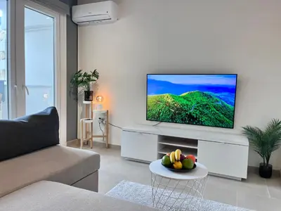 a living room with a flat screen tv on a wall at Monte Napa Moments in Ayia Napa
