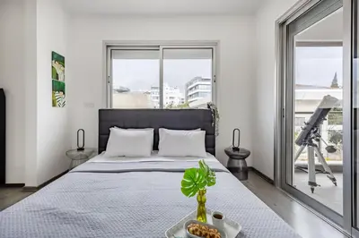 a bedroom with a bed with a table and a camera at Vasileos Konstantinou Modern 2BR City Apartment with Balcony in Limassol