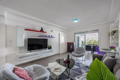 a living room with a couch and a tv at Vasileos Konstantinou Modern 2BR City Apartment with Balcony in Limassol