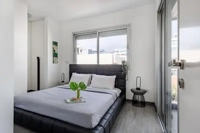 a bedroom with a black bed with a plant on it at Vasileos Konstantinou Modern 2BR City Apartment with Balcony in Limassol