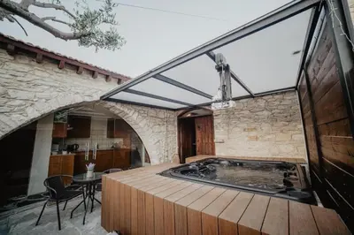 a hot tub in a room with a stone wall at Stonehouse in Monagri