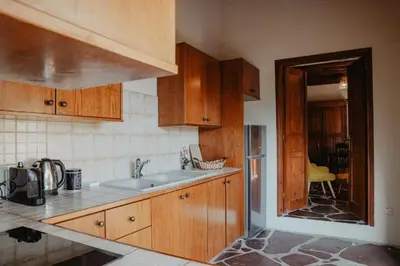 a kitchen with wooden cabinets and a sink at Stonehouse in Monagri