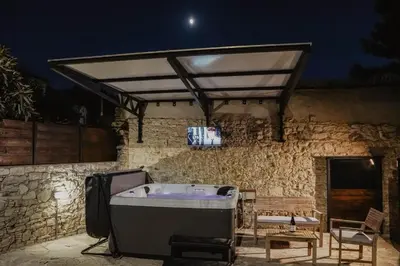 a bath tub sitting on a patio at night at Stonehouse in Monagri
