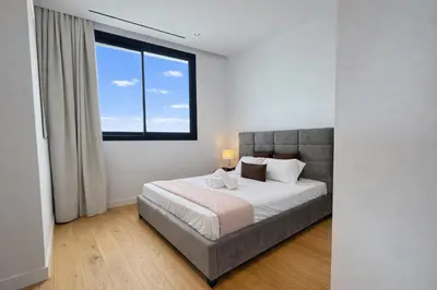 a bedroom with a large bed with a large window at Stasikratous Residence - 10th Floor Gym in Nicosia