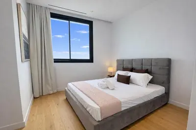 a bedroom with a large bed with a large window at Stasikratous Residence - 10th Floor Gym in Nicosia