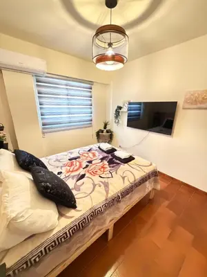 a bedroom with a bed with pillows and a television at SeaScape Eight in Larnaka