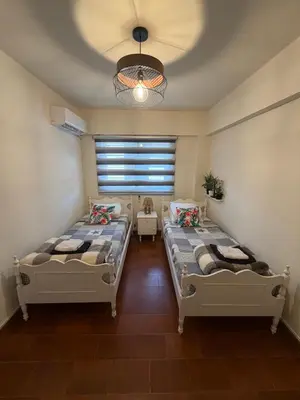 a bedroom with two beds and a window at SeaScape Eight in Larnaka