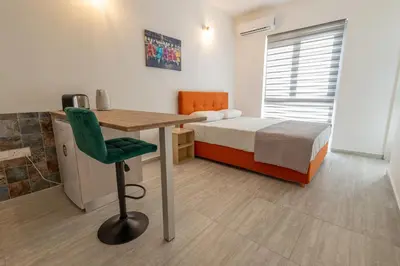 a small bedroom with a bed and a desk and a table at Studio in Limassol Coast in Limassol