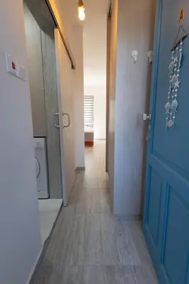 a hallway with a blue door and a washing machine at Studio in Limassol Coast in Limassol